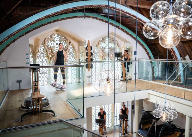 Featured image of people working out on raised fitness area featuring original stained glass windows