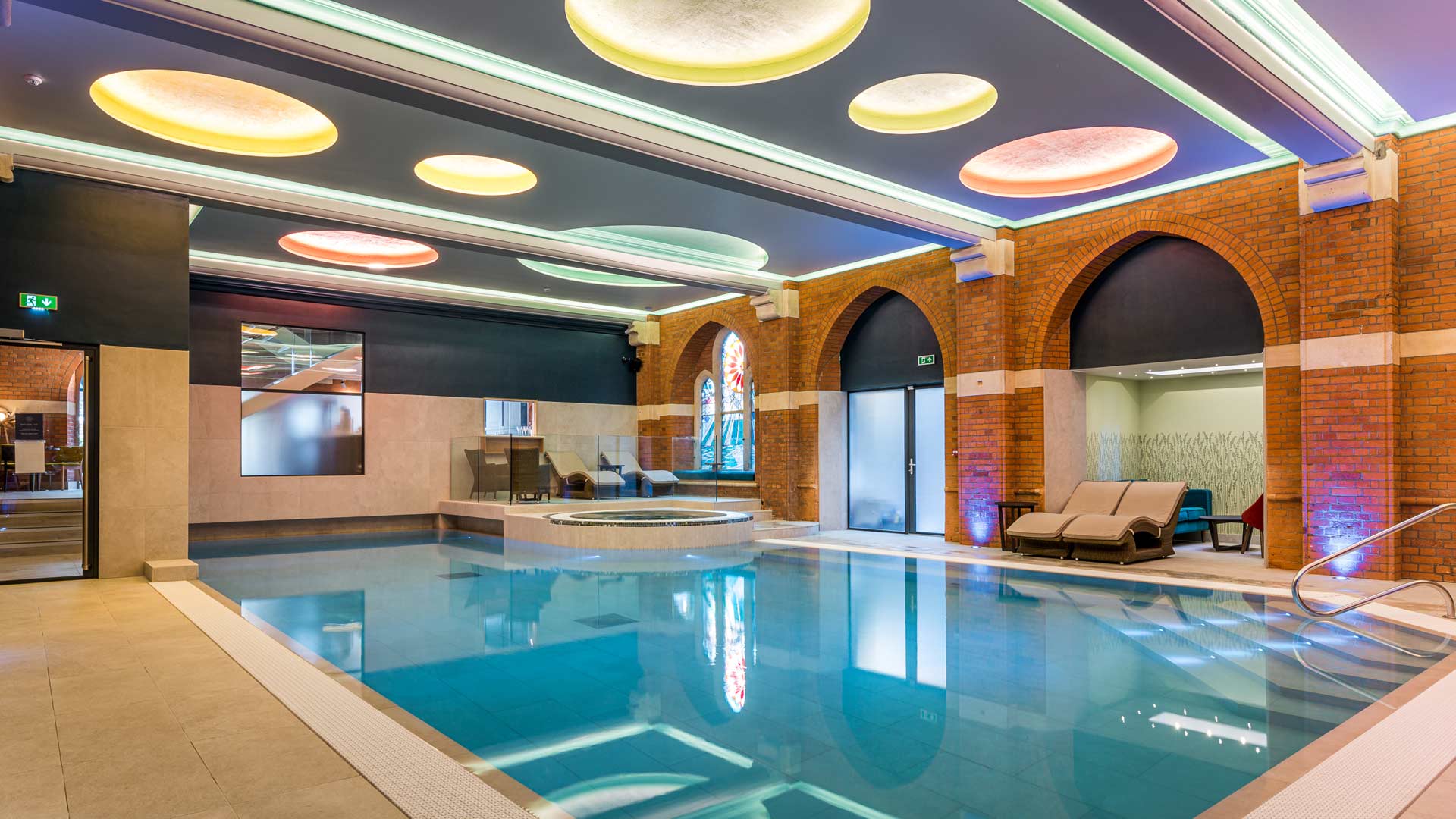 Bright and colourful wellness pool and spa area constructed in the church basement.