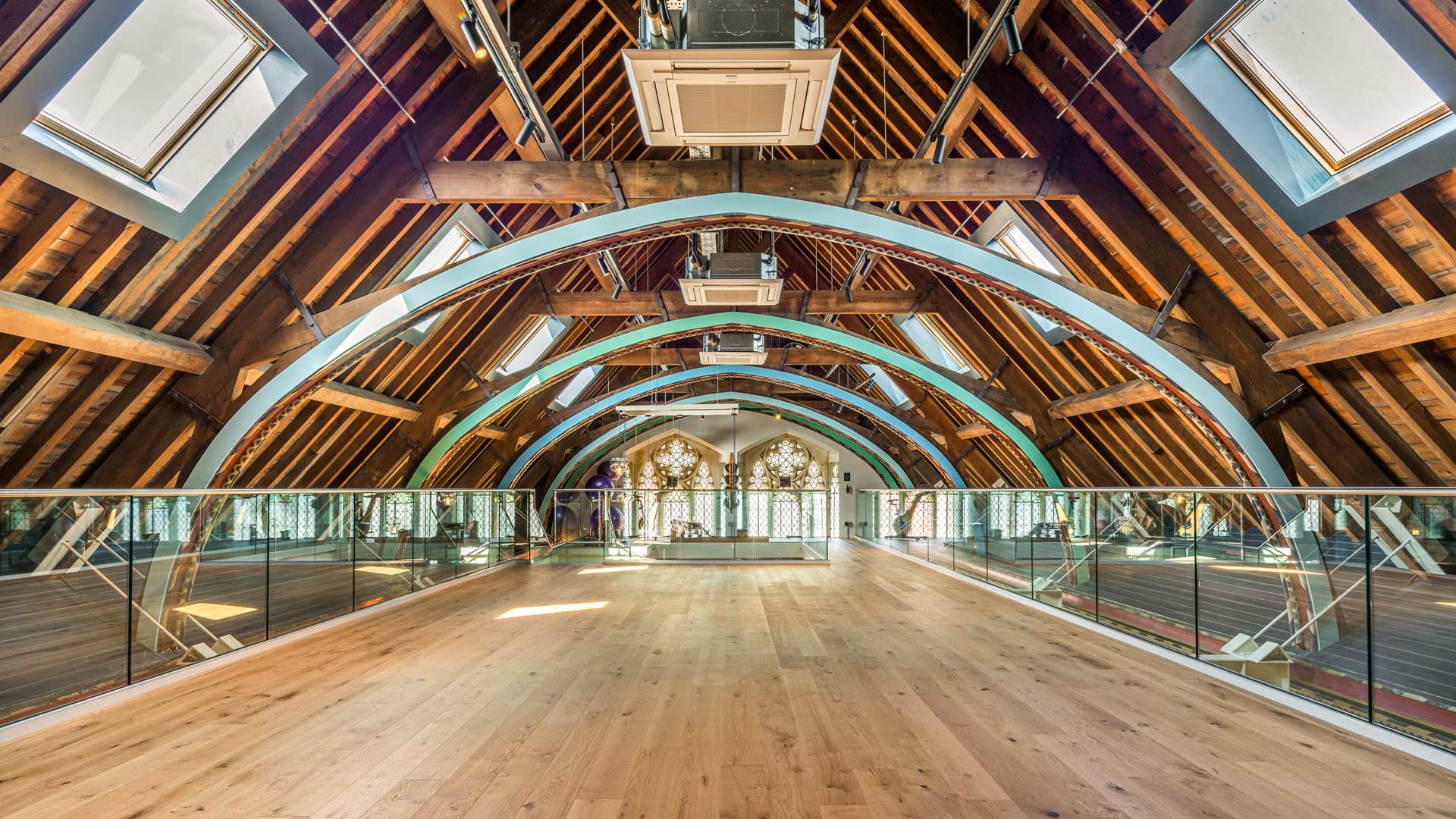 Original arched wooden church roof with skylights as feature of the upper level workout area
