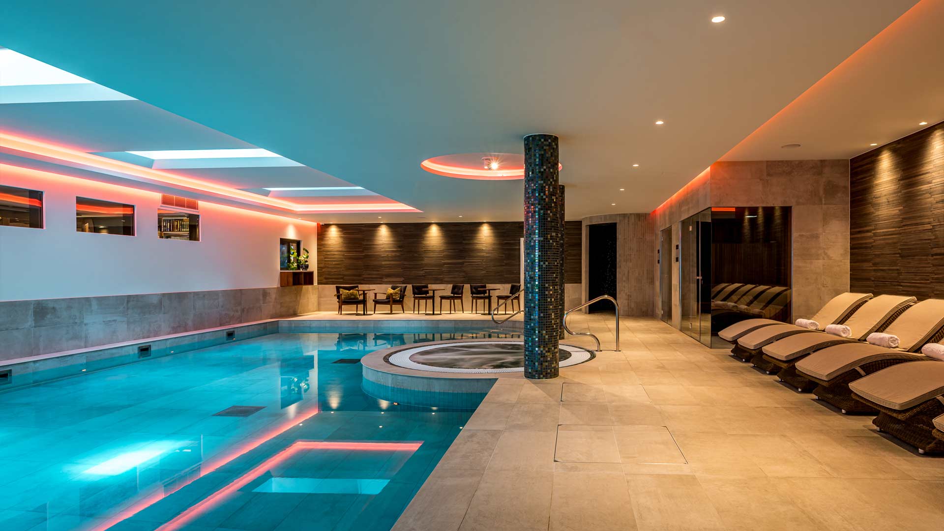 Modern swimming pool and spa area with jacuzzi and sauna.