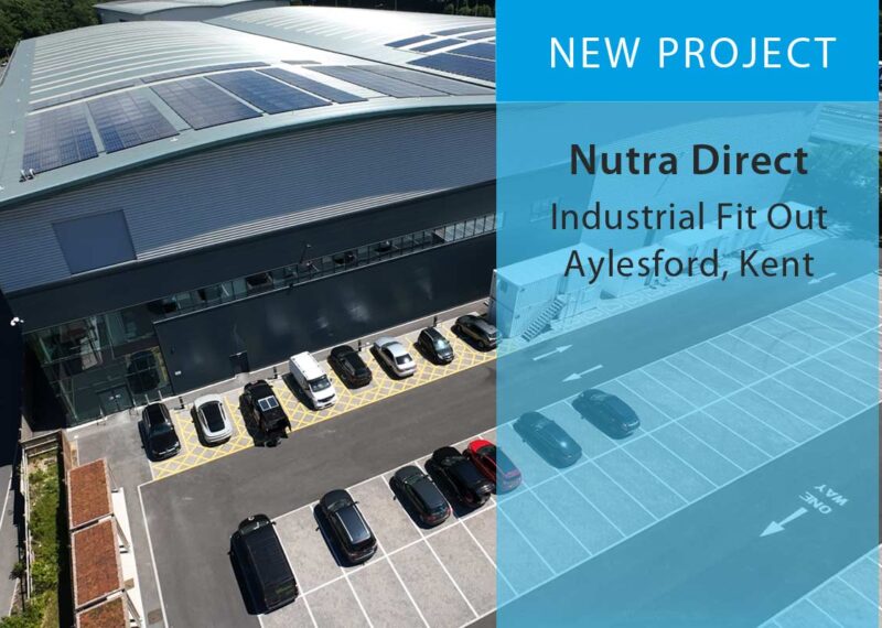 Aerial of large industrial warehouse building with parking, overlaid with text 'New Project - Nutra Direct, Industrial Fit Out, Aylesford, Kent